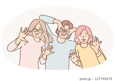 Happy girls of friend have fun making funny faces and putting fingers to faces instead of glasses 127748979