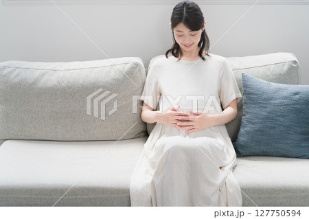 ソファーでくつろいでいる妊婦 ライフスタイルイメージ ソファーでくつろいでいる妊婦 ライフスタイルイメージ 127750594
