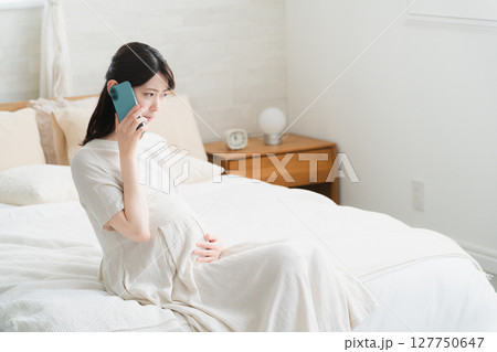 破水がきて病院に電話をする妊婦 ライフスタイルイメージ 破水がきて病院に電話をする妊婦 ライフスタイルイメージ 127750647