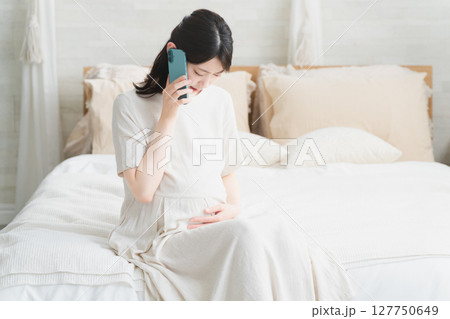 破水がきて病院に電話をする妊婦 ライフスタイルイメージ 破水がきて病院に電話をする妊婦 ライフスタイルイメージ 127750649