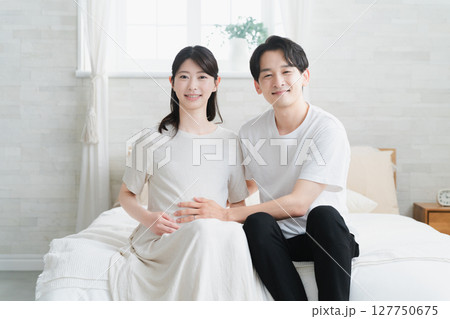 ベッドでくつろいでいる妊婦と夫 ライフスタイルイメージ ベッドでくつろいでいる妊婦と夫 ライフスタイルイメージ 127750675