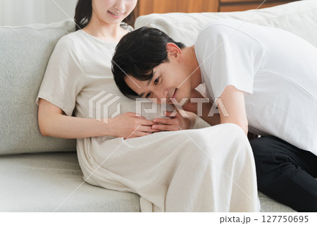 妊婦のお腹に耳を当てる夫　ライフスタイルイメージ 127750695