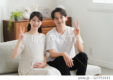 リビングのソファーでくつろぐ夫婦　ライフスタイルイメージ 127751015