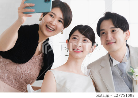 新郎新婦と撮影する友人　ウエディングイメージ 127751098