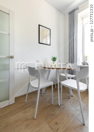 Bright Dining Nook with White Chairs and Wooden Floor Bright Dining Nook with White Chairs and Wooden Floor 127751310