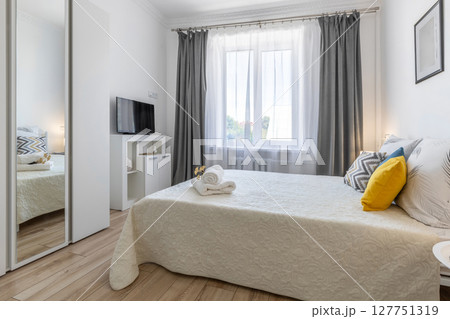 Bright Modern Bedroom with TV, Mirror and Decorated Bed Bright Modern Bedroom with TV, Mirror and Decorated Bed 127751319
