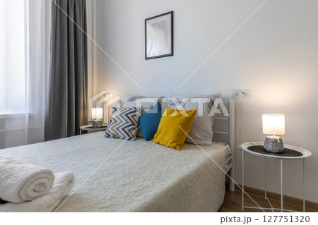 Minimalist Bedroom with Pillows, Towels and Cozy Lighting Minimalist Bedroom with Pillows, Towels and Cozy Lighting 127751320