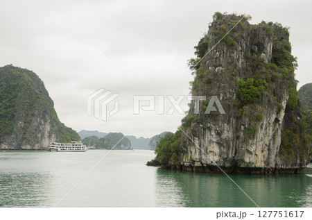 Tourist boat between limestone cliffs. Tourist boat between limestone cliffs. 127751617