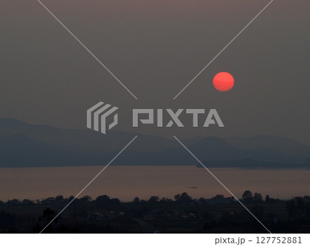 静かな夕暮れ時、淡い色彩の背景と猪苗代湖上空に浮かぶ真っ赤な太陽が印象的で綺麗だ。 127752881