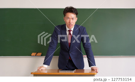 真剣な表情で話す男性教師 127753154