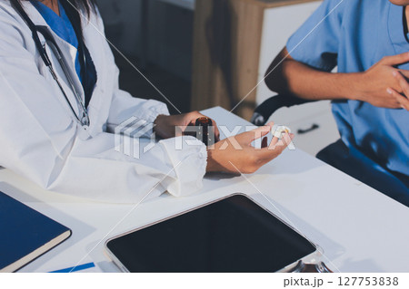 Young brunette woman having consultation at doctor office during Young brunette woman having consultation at doctor office during 127753838