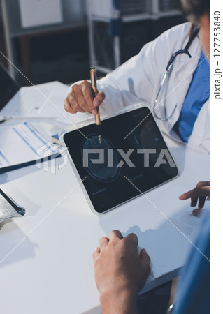 Cropped shot of an unrecognisable doctor sitting with his patient and showing her x-rays on a digital tablet Cropped shot of an unrecognisable doctor sitting with his patient and showing her x-rays on a digital tablet 127753840