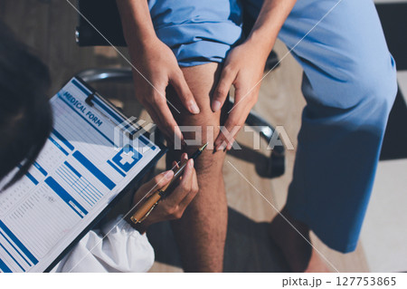 Physical therapist teaching a patient how to do exercises for his knee pain Physical therapist teaching a patient how to do exercises for his knee pain 127753865