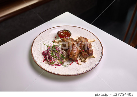 Grilled meat with onion salad and sauce 127754403