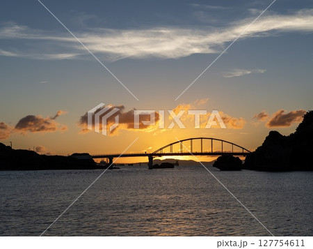 伊計島から見る夕焼けに包まれた伊計大橋のシルエット 127754611