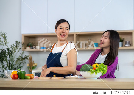 Healthy Cooking with Friends. Two women enjoying cooking together in a modern kitchen. Healthy Cooking with Friends. Two women enjoying cooking together in a modern kitchen. 127754796