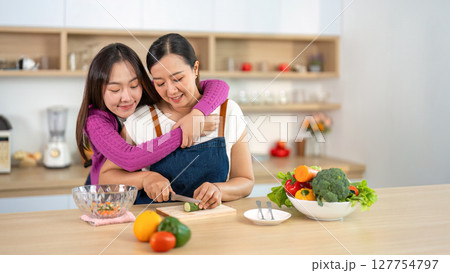 Cooking Together. Women sharing a loving moment while preparing a healthy meal in the kitchen. 127754797