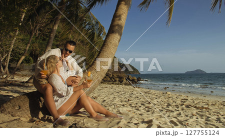 Loving couple in white dress and sunglasses, near palm tree, rel Loving couple in white dress and sunglasses, near palm tree, rel 127755124