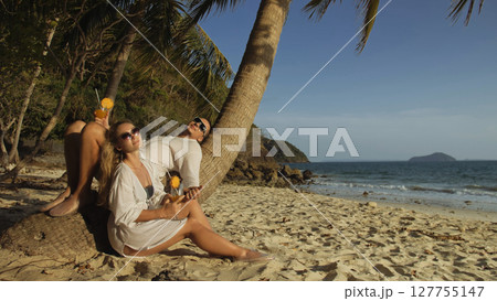 Loving couple in white dress and sunglasses, near palm tree, rel Loving couple in white dress and sunglasses, near palm tree, rel 127755147