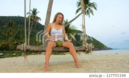 Attractive woman is swinging on a swing. Sexy hot erotic bad girl posing on the beach against the backdrop of the sea. Attractive woman is swinging on a swing. Sexy hot erotic bad girl posing on the beach against the backdrop of the sea. 127755199