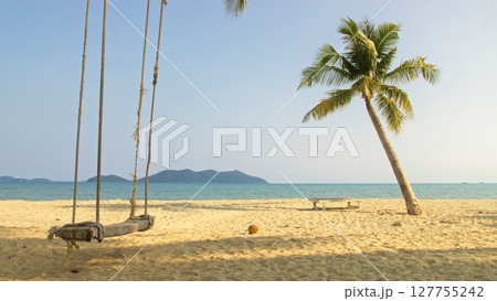 Seductive woman swinging on a swing on a tropical beach, on shores of the turquoise sea. Concept travel, walks, rest in sea, tropical resort coastline relaxation traveling tourism summer holidays. 127755242
