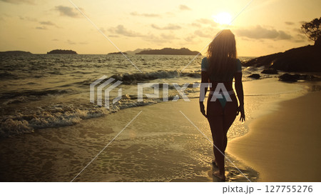 Sexy woman walking alone on beach coastline and relax warm golde 127755276