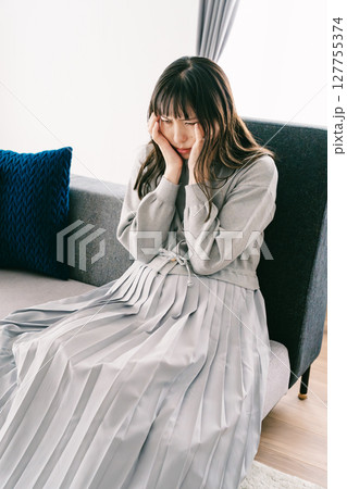 お腹が張って苦しさを感じる妊婦 127755374