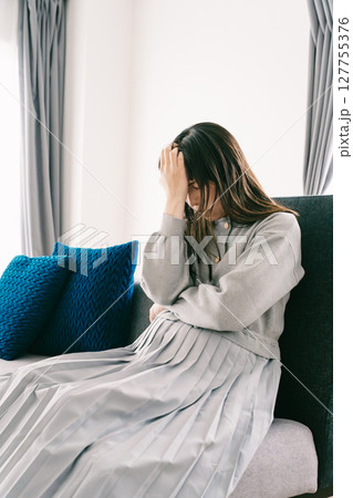 お腹が張って苦しさを感じる妊婦 127755376