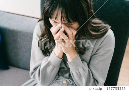 お腹が張って苦しさを感じる妊婦 127755383