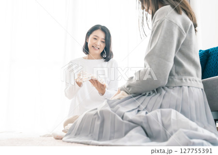 出産準備をしながら明るい未来の話をする母と娘 出産準備をしながら明るい未来の話をする母と娘 127755391