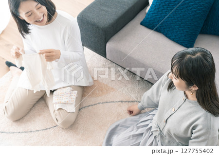 出産準備をしながら明るい未来の話をする母と娘 出産準備をしながら明るい未来の話をする母と娘 127755402