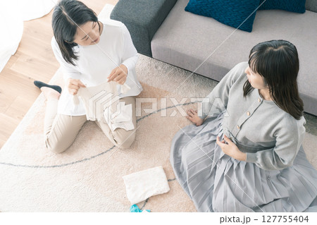 出産準備をしながら明るい未来の話をする母と娘 出産準備をしながら明るい未来の話をする母と娘 127755404