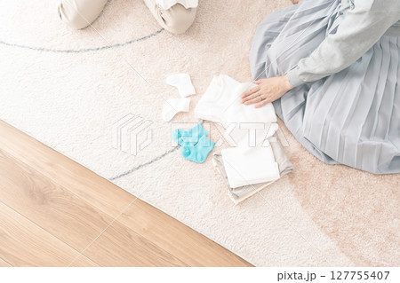 出産準備をしながら明るい未来の話をする母と娘 出産準備をしながら明るい未来の話をする母と娘 127755407