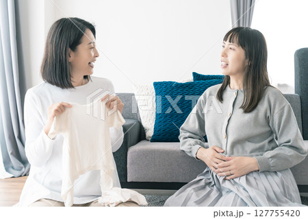 出産準備をしながら明るい未来の話をする母と娘 出産準備をしながら明るい未来の話をする母と娘 127755420