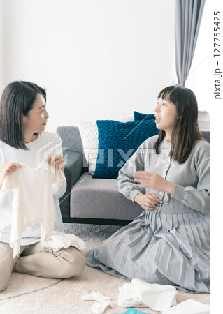 出産準備をしながら明るい未来の話をする母と娘 出産準備をしながら明るい未来の話をする母と娘 127755425
