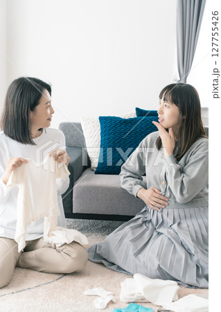 出産準備をしながら明るい未来の話をする母と娘 出産準備をしながら明るい未来の話をする母と娘 127755426