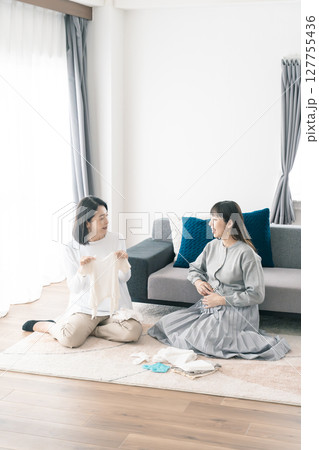 出産準備をしながら明るい未来の話をする母と娘 出産準備をしながら明るい未来の話をする母と娘 127755436