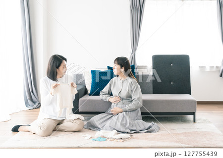 出産準備をしながら明るい未来の話をする母と娘 出産準備をしながら明るい未来の話をする母と娘 127755439