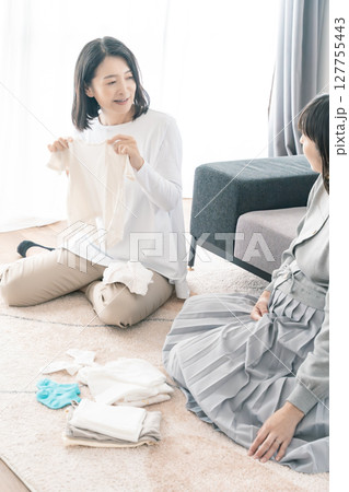 出産準備をしながら明るい未来の話をする母と娘 出産準備をしながら明るい未来の話をする母と娘 127755443