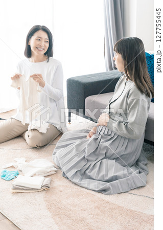 出産準備をしながら明るい未来の話をする母と娘 127755445