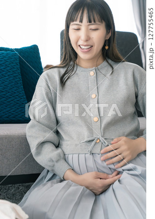 出産準備をしながら明るい未来の話をする母と娘 127755465