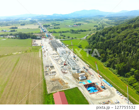 初夏の北海道八雲町でJR北海道新幹線八雲駅周辺工事現場の風景を空撮 127755532