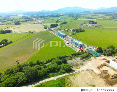 初夏の北海道八雲町でJR北海道新幹線八雲駅周辺工事現場の風景を空撮 127755553