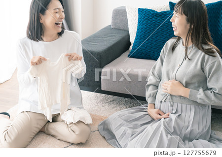 出産準備をしながら明るい未来の話をする母と娘 出産準備をしながら明るい未来の話をする母と娘 127755679