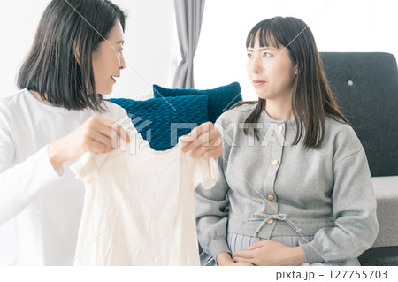 出産準備をしながら明るい未来の話をする母と娘 127755703