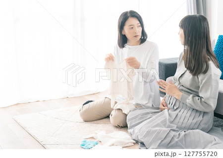 出産準備をしながら明るい未来の話をする母と娘 127755720