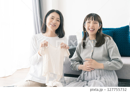 出産準備をしながら明るい未来の話をする母と娘 127755732
