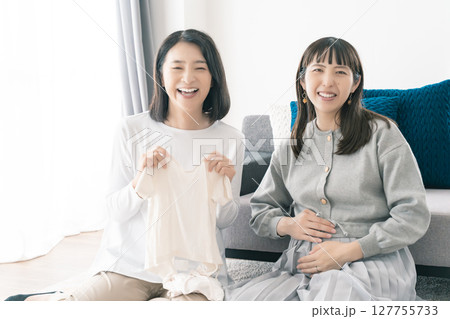 出産準備をしながら明るい未来の話をする母と娘 127755733
