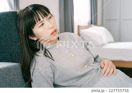 お腹が張って苦しさを感じる妊婦 お腹が張って苦しさを感じる妊婦 127755738