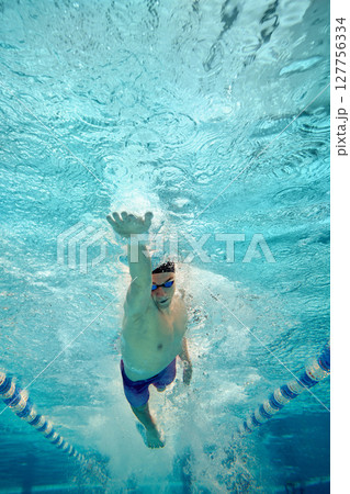 Underwater view of swimmer performing freestyle stroke in pool Underwater view of swimmer performing freestyle stroke in pool 127756334